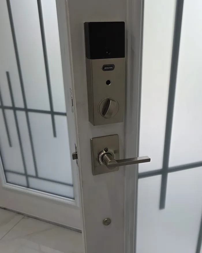 Finished keypad deadbolt and lever handle on a white side door